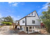 Exterior view of home with white siding, black trim, and a wooden porch with stairs at 5780 Bearing Way, Atlanta, GA 30349