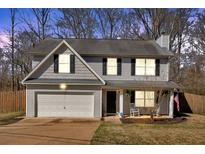 Charming two-story home with an attached garage and a cozy front porch featuring rocking chairs at 81 Summer Creek Dr, Dallas, GA 30157