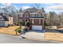 Charming brick home with well-manicured lawn and two-car garage at 1039 Ashfern Walk, Woodstock, GA 30189