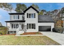 Charming two-story home with white brick, black shutters, and a well-manicured front lawn at 1285 Cedar Brook Dr, Lawrenceville, GA 30043