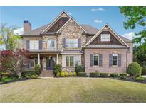 Beautiful two-story brick and stone home with professionally landscaped front yard and covered porch at 1655 Dawn Dr, Suwanee, GA 30024