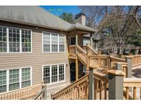 Inviting exterior view showcasing a two-story home with wooden decks and lots of windows for natural light at 303 Mill Pond Se Ct, Smyrna, GA 30082