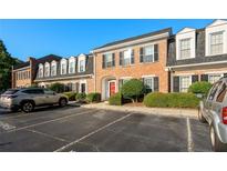 Charming brick townhome with well-maintained landscaping and reserved parking spaces at 4 Kings Tavern Nw, Atlanta, GA 30318