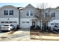 Charming townhome with a clean white exterior, garage, and well-maintained landscaping at 5432 Plain Field Ln, Lilburn, GA 30047