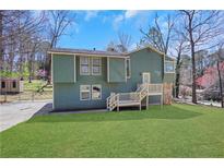 Inviting home featuring a spacious lawn, wood siding, stone accents, and a charming front entrance at 3136 Taffy Ln, Snellville, GA 30039