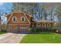 Charming two-story home with a well-manicured front lawn, garage, and inviting porch at 4453 Abingdon Dr, Stone Mountain, GA 30083