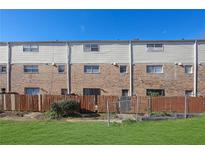 Townhome exterior featuring a combination of brick and siding, fenced yard and green grass at 4701 Flat Shoals Rd # 49C, Union City, GA 30291
