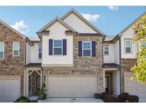 Charming townhome with brick and siding, featuring a two-car garage and stylish blue shutters at 1484 Ben Park Way, Grayson, GA 30017