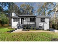 Charming renovated home features a welcoming front porch and beautifully landscaped yard at 2735 Varlet Ct, Snellville, GA 30039