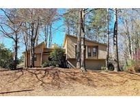 Charming home with unique architectural details surrounded by mature trees offering shade and privacy at 4752 N Springs Nw Rd, Kennesaw, GA 30144
