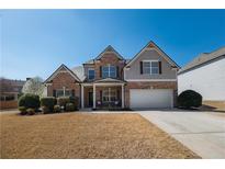 Charming two-story brick home with attached two-car garage and manicured front lawn at 5035 Lloyd Ln, Cumming, GA 30040