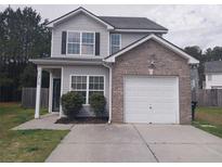 Charming two-story home with a brick-accented garage and well-maintained front yard at 315 Dressage Ct, Riverdale, GA 30296