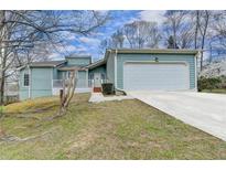 Charming single-story home with a two-car garage and well-maintained lawn, complemented by mature trees at 639 Oak Moss Dr, Lawrenceville, GA 30043