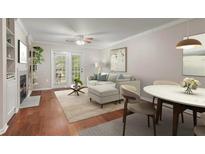 Bright living room with hardwood floors, fireplace, ceiling fan, and access to outdoor space at 3655 Habersham Ne Rd # 215, Atlanta, GA 30305