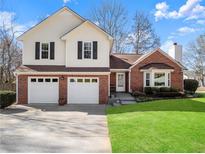 Charming two-story home with a brick and vinyl exterior and well-maintained lawn at 6920 Greenfield Ln, Cumming, GA 30028