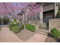 Charming brick townhome featuring lush landscaping and an inviting gated entrance at 91 Webb St, Roswell, GA 30075