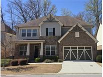 Charming brick and siding two-story home featuring an attached two-car garage and manicured landscaping at 112 Austin Dr, Sandy Springs, GA 30328