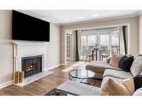 Bright living room featuring a fireplace, large TV, and comfortable sectional sofa near a table and chairs at 3201 Lenox Ne Rd # 23, Atlanta, GA 30324