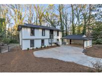 Charming two-story home featuring a carport, manicured landscaping, and a freshly painted exterior at 353 Colchester Dr, Stone Mountain, GA 30088