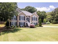 Charming two-story home featuring black shutters, a manicured lawn and inviting front entrance and manicured yard at 2515 Little John Ct, Cumming, GA 30040