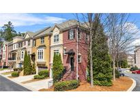 Charming brick townhome with manicured landscaping and a private entrance, offering a warm and inviting curb appeal at 928 Boudreau Ct, Atlanta, GA 30328