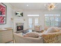 Cozy living room with fireplace, TV, elegant decor, and natural light from a large window at 928 Boudreau Ct, Atlanta, GA 30328