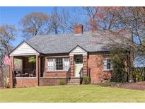 Charming brick home with a covered porch and well-maintained front lawn at 1328 Briarwood Ne Dr, Atlanta, GA 30306