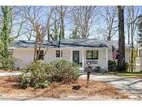 Charming single-story home with a covered porch, well-maintained landscaping, and American flag at 3841 Admiral Dr, Atlanta, GA 30341