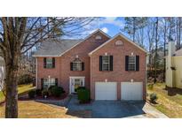 Charming two-story brick home with a manicured front yard and a two-car garage at 3521 Kittery Dr, Snellville, GA 30039