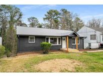 Charming home featuring a dark brick exterior, inviting front porch, and well-maintained lawn at 1282 Westridge Sw Rd, Atlanta, GA 30311