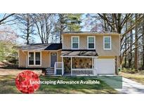 Charming two-story home with stone accents, front porch, well-manicured lawn, and attached garage at 1946 Taffeta Trl, Lithonia, GA 30058