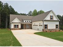Beautiful, modern farmhouse-style home with a three-car garage and a long driveway at 215 Pinewood Dr, Covington, GA 30014