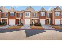 Charming townhome exterior with brick facade, attached garage, and well-maintained landscaping at 2411 Heritage Park Nw Cir # 14, Kennesaw, GA 30144