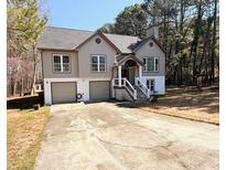 Charming two-story home with a welcoming entrance, two-car garage, and a long driveway at 5011 Cliff Top Dr, Loganville, GA 30052