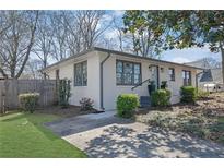 Charming painted brick home with gray trim, green lawn, and manicured landscaping at 965 Carr Nw St, Atlanta, GA 30318