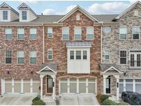 Charming townhomes featuring diverse brick and stone facades, complemented by symmetrical garage doors at 4125 Barry Pl, Chamblee, GA 30341