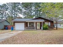Cozy single-story home with a white garage door, front porch, and lawn at 6347 Steepleridge Ct, Riverdale, GA 30296