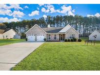 Charming single-story brick home with a well-manicured lawn and a two-car garage at 149 Fears Dr, Hampton, GA 30228