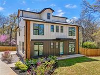 Striking new construction featuring a modern farmhouse style with a manicured lawn, and black framed windows at 3087 Alston Dr, Decatur, GA 30032