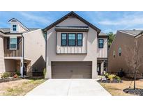 Charming exterior showcasing a well-maintained lawn, gray siding, and an attached two-car garage at 3040 Westgate Park Dr, Loganville, GA 30052