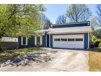 Charming blue home with a two-car garage and well-maintained lawn at 2645 Trotters Walk Trl, Snellville, GA 30078