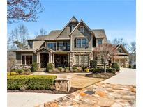 Stunning two-story home with stone accents, manicured landscaping and a driveway leading to an attached garage at 268 Hanson Way, Marietta, GA 30064