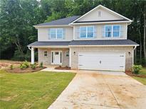 Charming two-story home featuring a brick facade, inviting entrance, and a two-car garage at 309 Melanie Ct, Bowdon, GA 30108