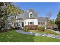 Charming white brick home with a well-manicured front yard and a stone pathway leading to the entrance at 435 Collier Nw Rd, Atlanta, GA 30309