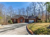 Charming red brick home with attached garage and a well-maintained, tree-lined front yard at 5060 Governors Walk Dr, Canton, GA 30115