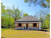 Charming single-story home featuring a welcoming front porch with a manicured lawn and natural light at 6592 Factory Shoals Sw Rd, Mableton, GA 30126