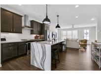 Modern kitchen with stainless steel appliances, dark cabinets, marble countertops and an island with bar seating at 1181 Rambler Cross, Atlanta, GA 30312