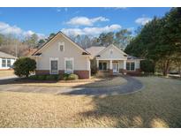 Charming home features a landscaped front yard, brick accents, and a welcoming entrance, radiating curb appeal at 153 Newcastle Walk, Woodstock, GA 30188