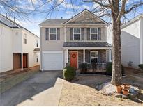 Charming two-story home featuring stone accents, a cozy front porch, manicured shrubs, and a one-car garage at 5790 Mountain Top Pl, Cumming, GA 30041