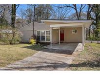 Charming single-story home with a quaint carport and a red front door, set amidst lush greenery at 2254 Whites Mill Rd, Decatur, GA 30032